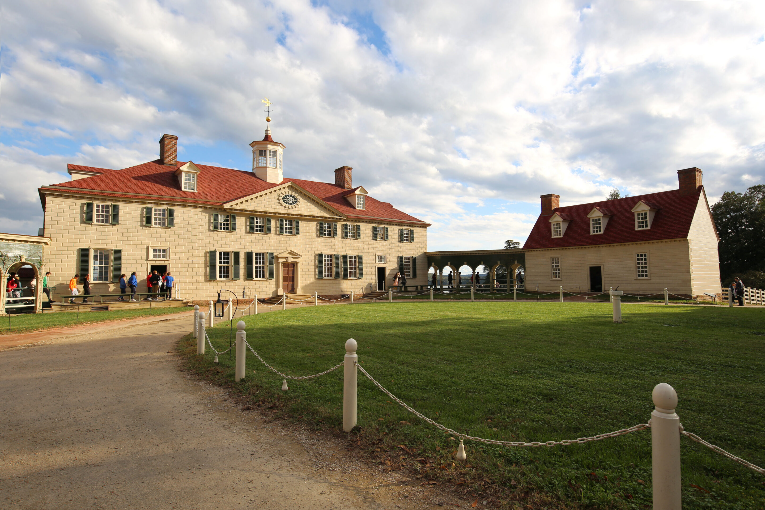 Historic estate with red roofs and lawn.