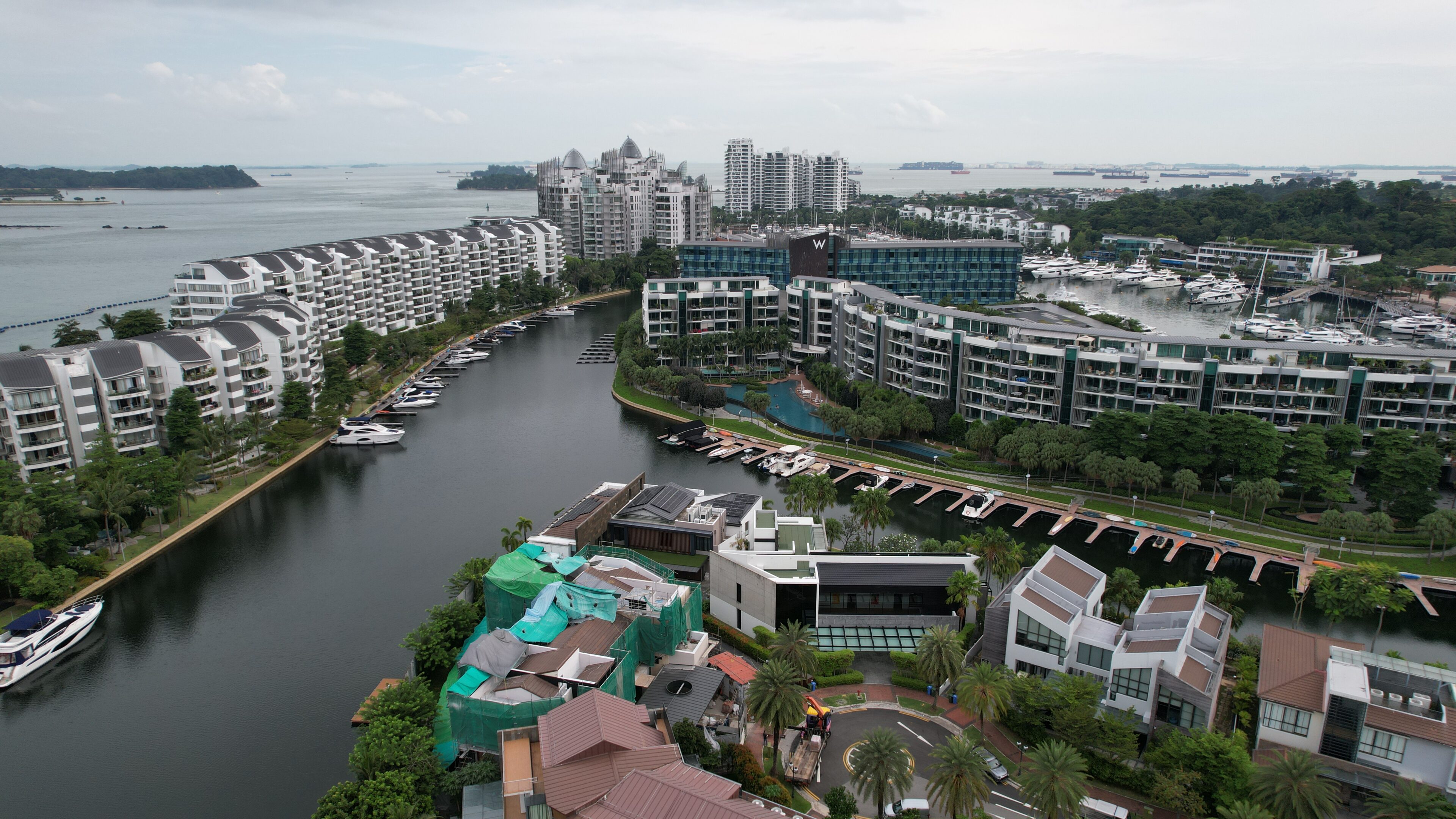 Waterfront residential area with boats and greenery.