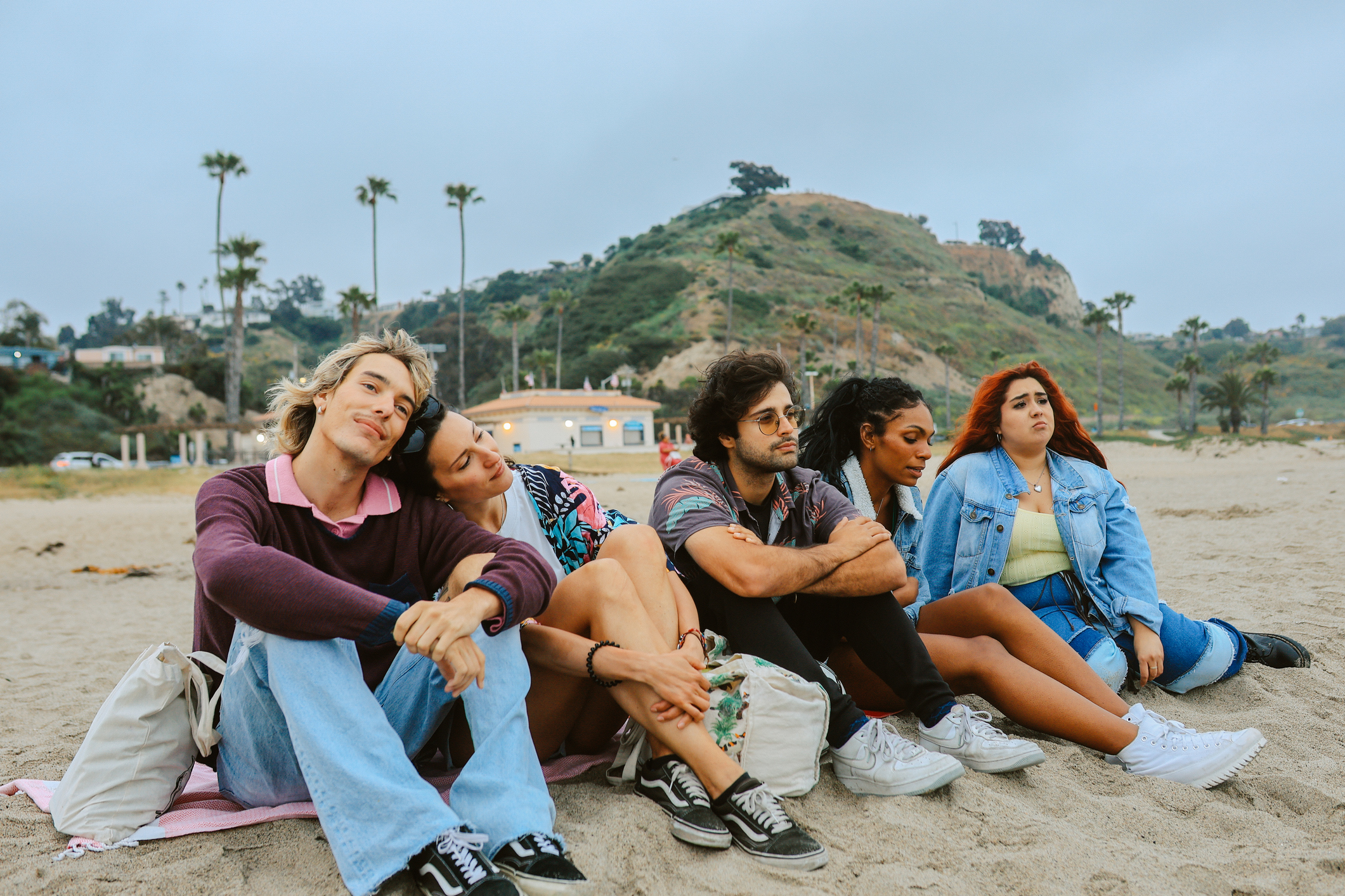 Group of friends sitting on a beach.