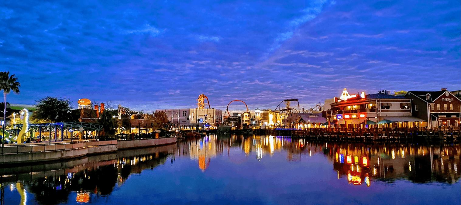 Amusement park skyline reflecting on water.