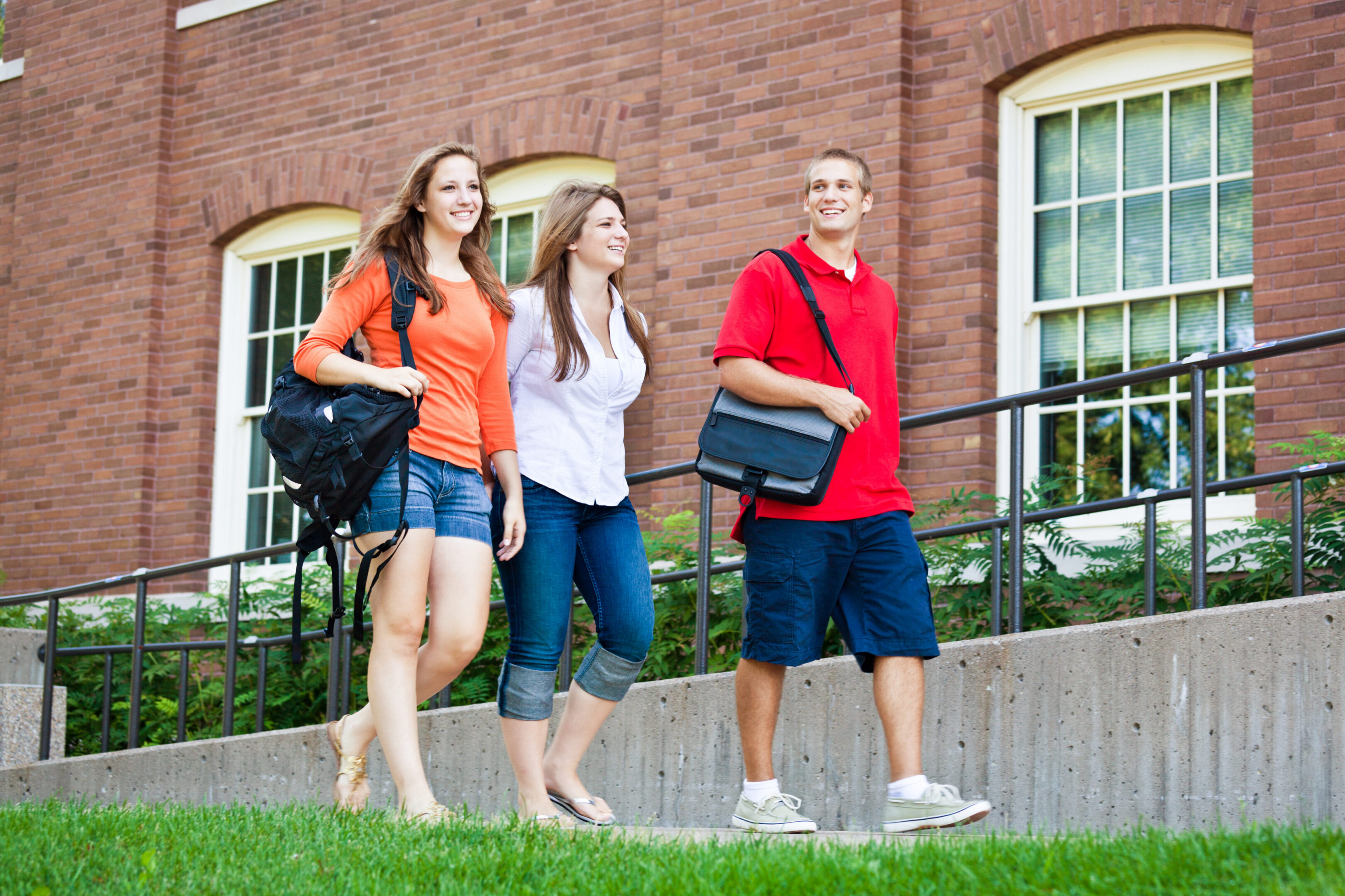 Students walking outside a brick building.
