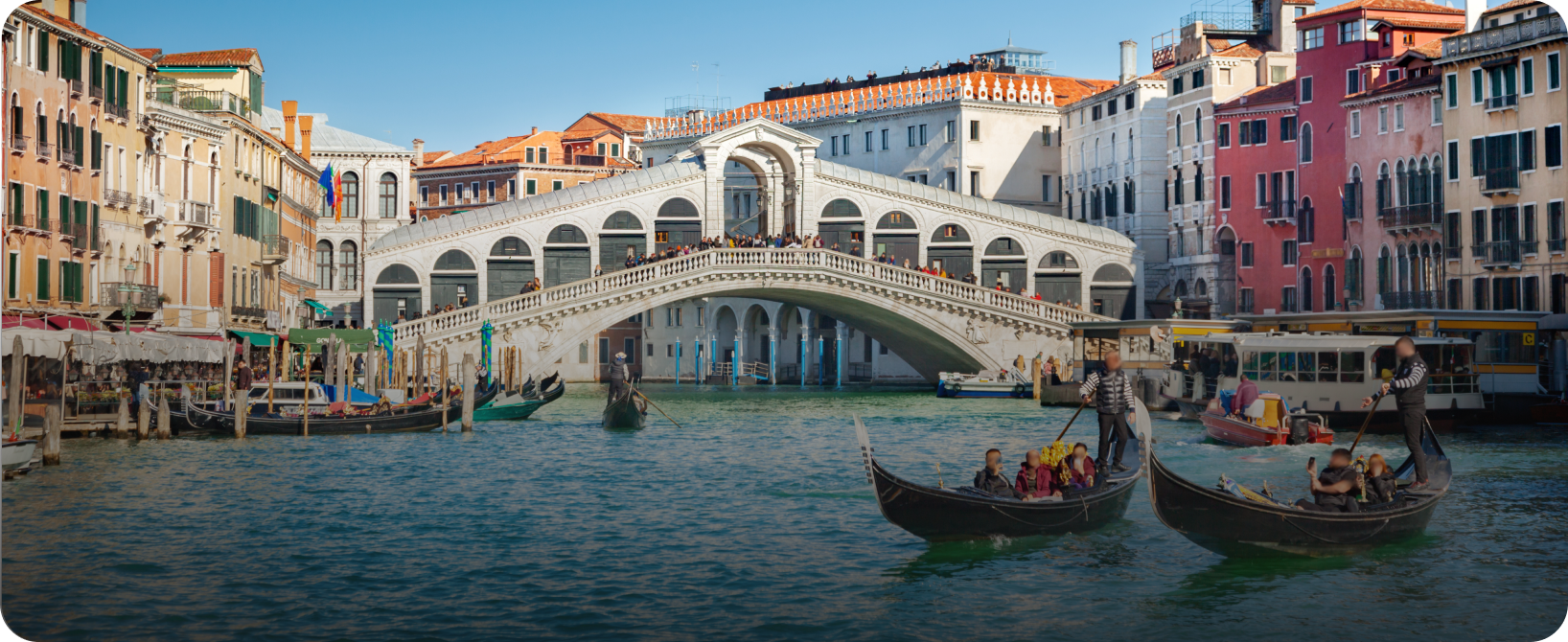 Venice canal with gondolas and Rialto Bridge.