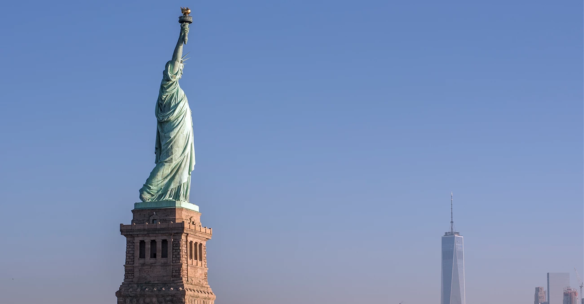 Statue of Liberty with city skyline background.